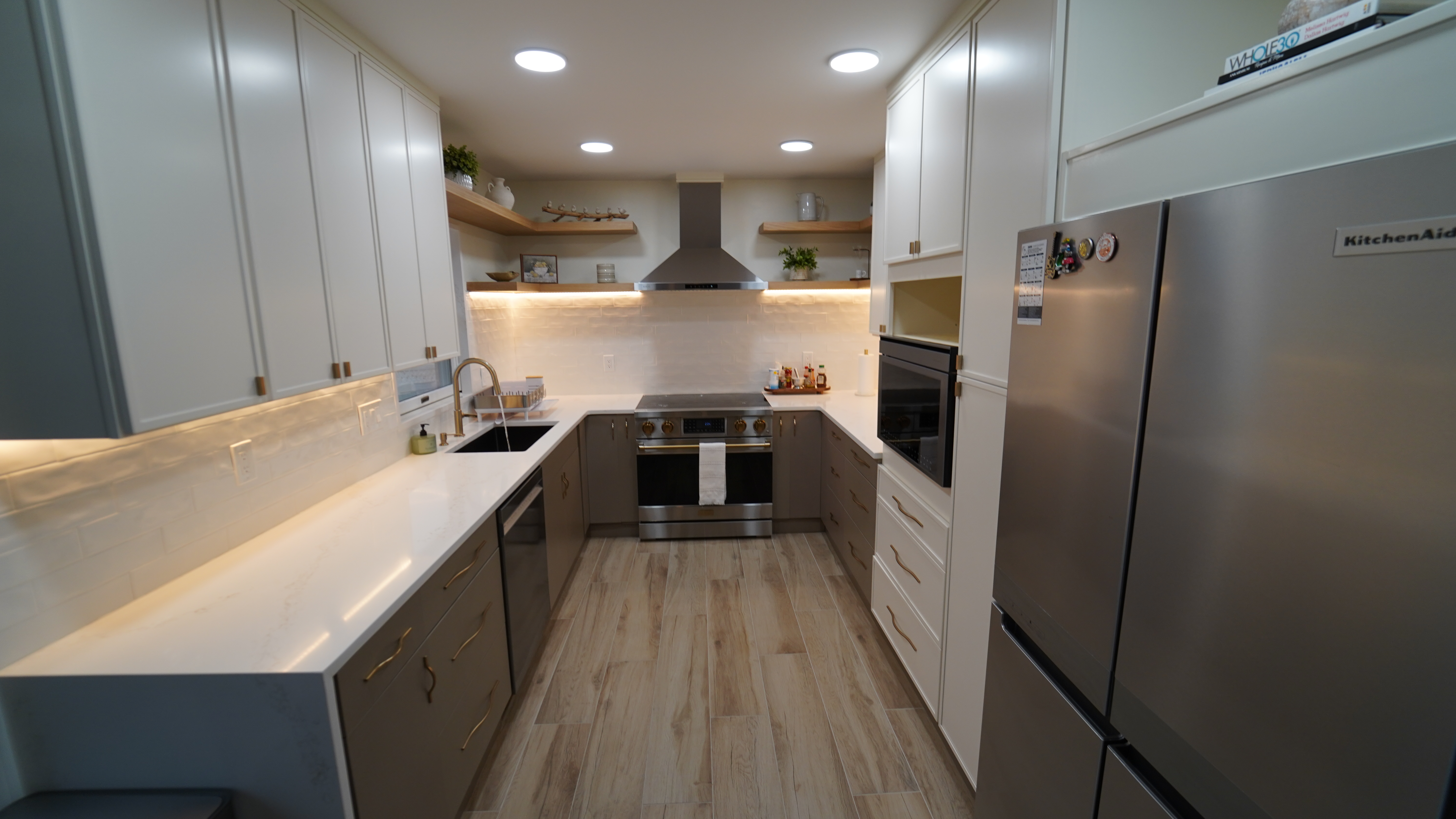 Saugus kitchen with stainless appliances, open shelving, and warm lighting