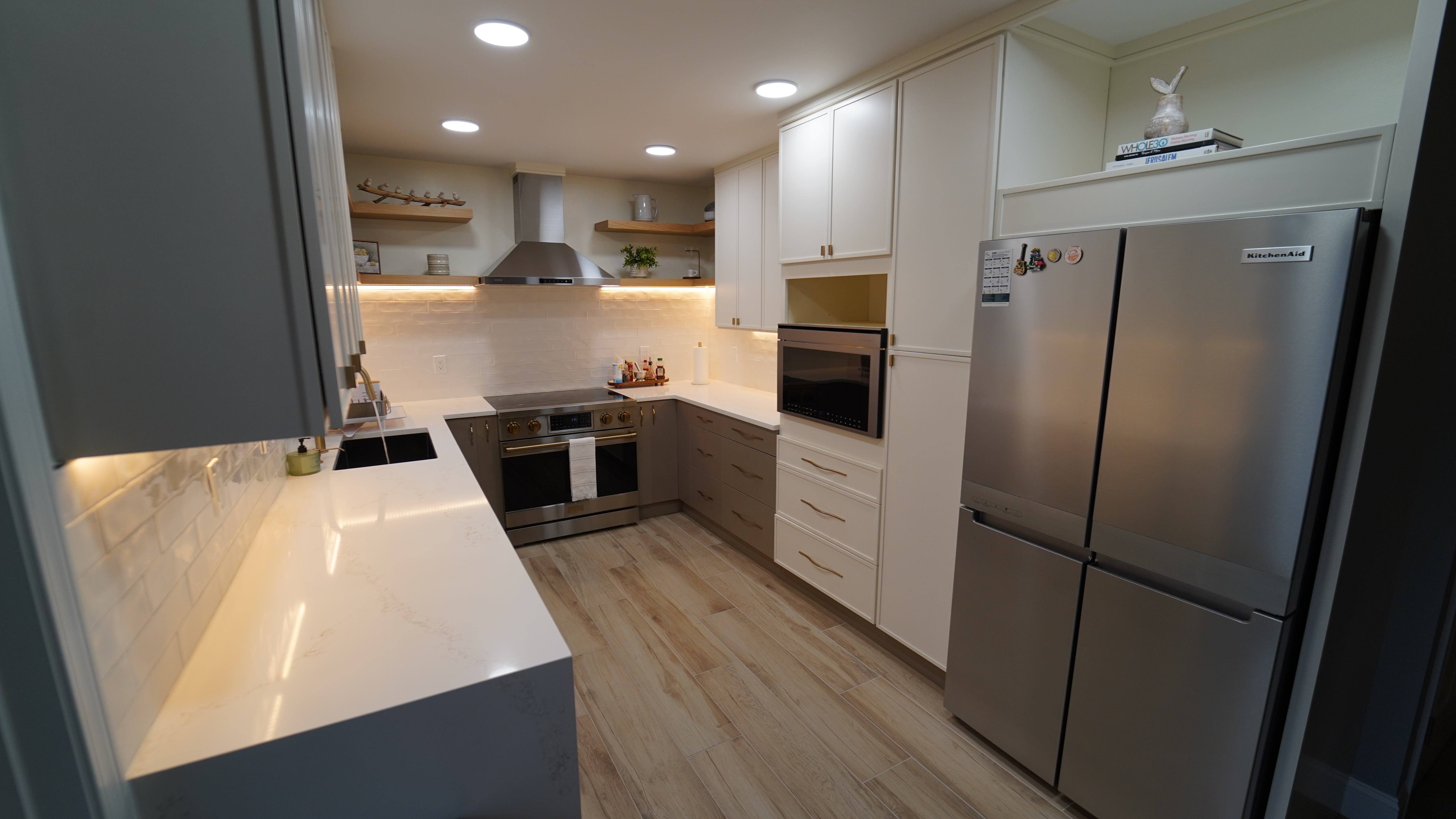 Saugus kitchen view with refrigerator wall, oven tower, and quartz-style counters